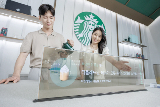 16일 서울 코엑스에서 열린 'K디스플레이 2023' 전시회에서 LG디스플레이 모델이 스타벅스와 협업한 매장용 투명 OLED 콘셉트를 소개하고 있다. LG디스플레이 제공